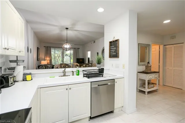 a kitchen that has a sink and chairs in it