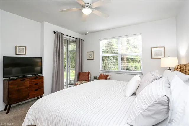 a bedroom with a large bed and a flat tv screen on dresser
