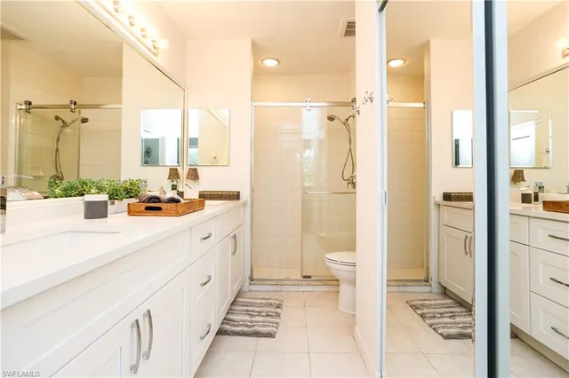 a bathroom with a double vanity sink toilet and shower