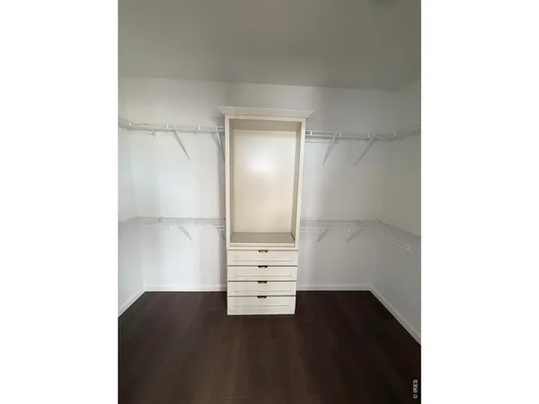 a view of walk in closet with wooden floor