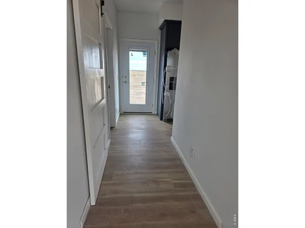 a view of a hallway with wooden floor
