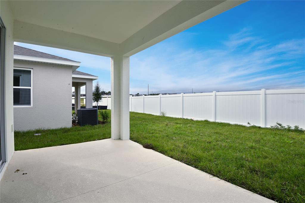 145 Waterstone Loop Tavares, FL 32778 - Photo 15 of 16 a view of a backyard with table and chairs and wooden fence