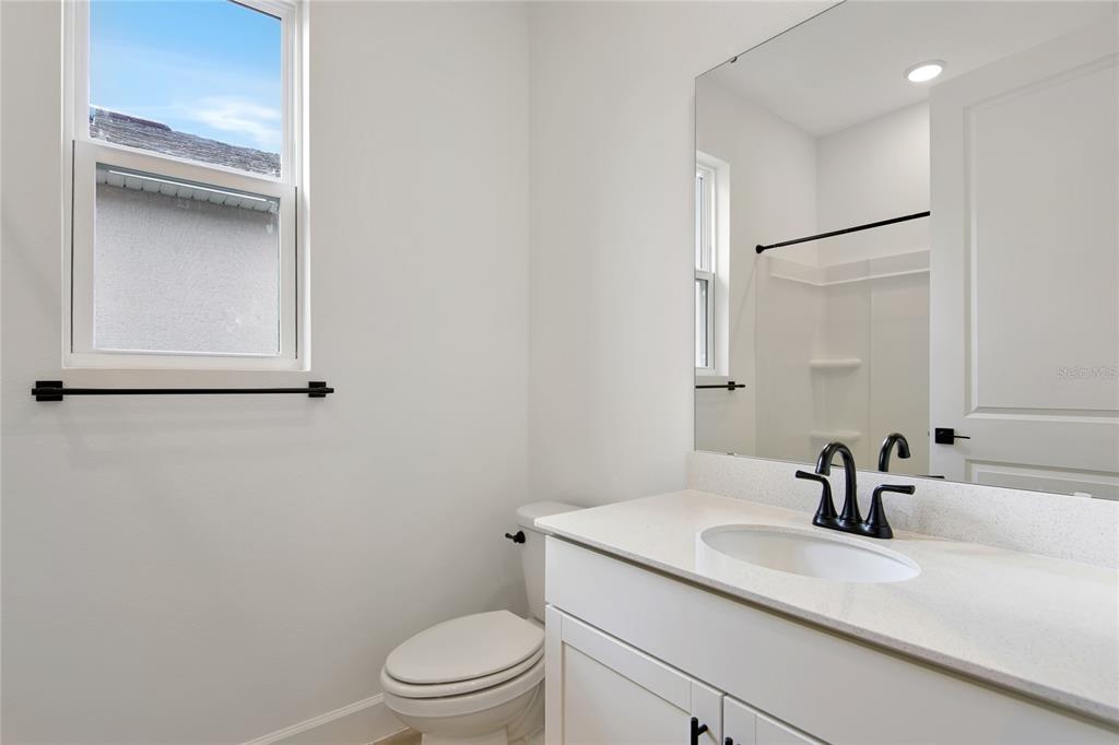 145 Waterstone Loop Tavares, FL 32778 - Photo 4 of 16 a bathroom with a sink a toilet and a mirror