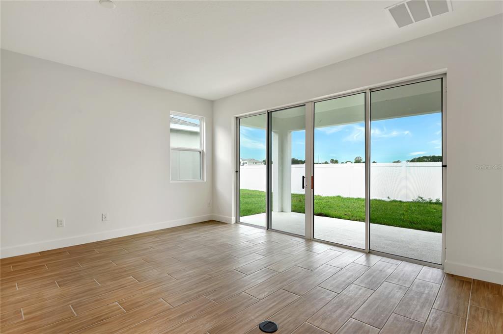 145 Waterstone Loop Tavares, FL 32778 - Photo 8 of 16 a view of an empty room with wooden floor and fan
