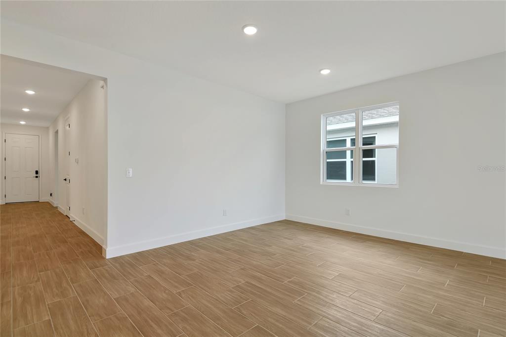 145 Waterstone Loop Tavares, FL 32778 - Photo 9 of 16 a view of empty room with wooden floor and fan