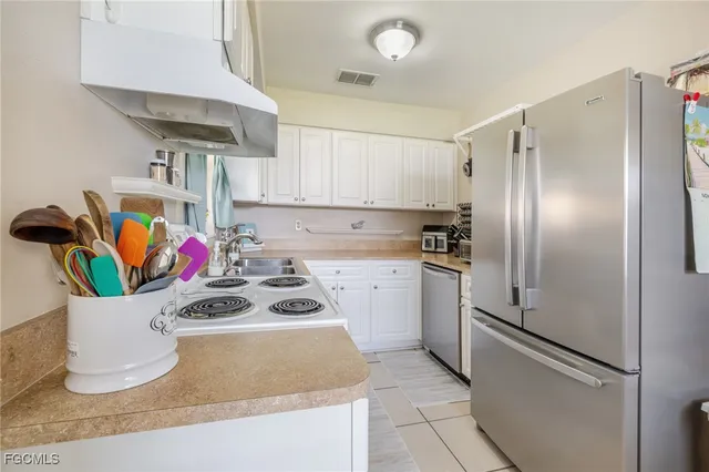 a kitchen with a stove a sink and cabinets