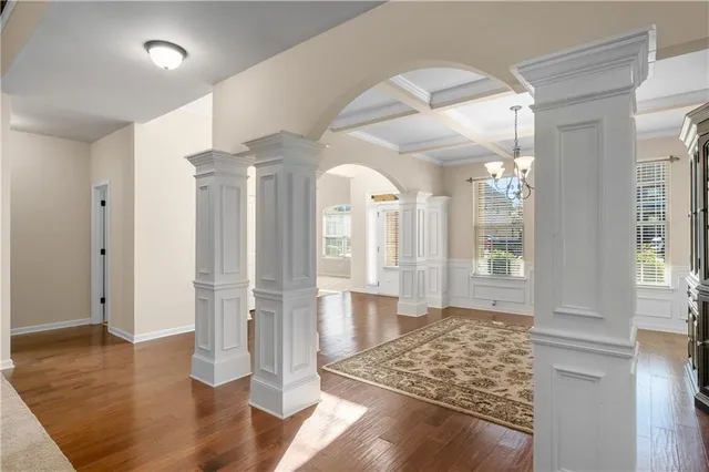 a view of a hallway with wooden floor and a living room