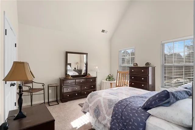 a bedroom with a bed and dresser with mirror