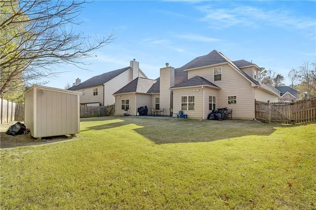 a view of a white house with a yard and a large tree