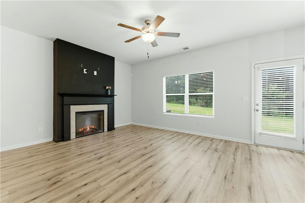 7492 Knoll Hollow Road Lithonia, GA 30058 - Photo 8 of 30 a view of an empty room with wooden floor and a window
