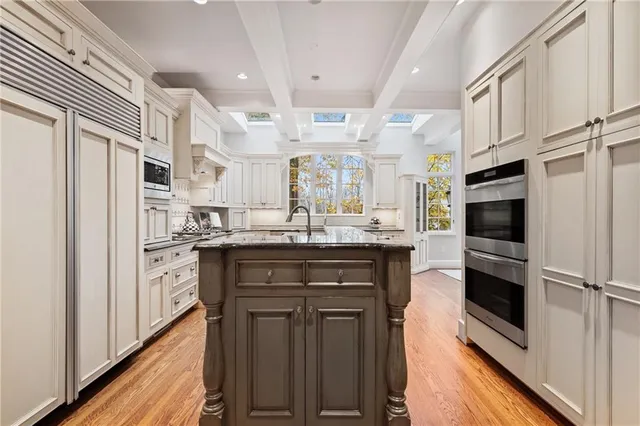 a kitchen with granite countertop a sink cabinets and wooden floor