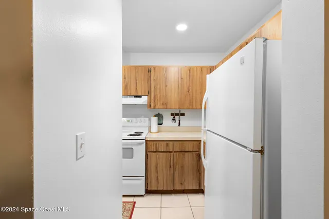 a kitchen with a sink a refrigerator and cabinets