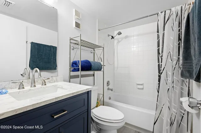 a bathroom with a sink a toilet a mirror a vanity and shower