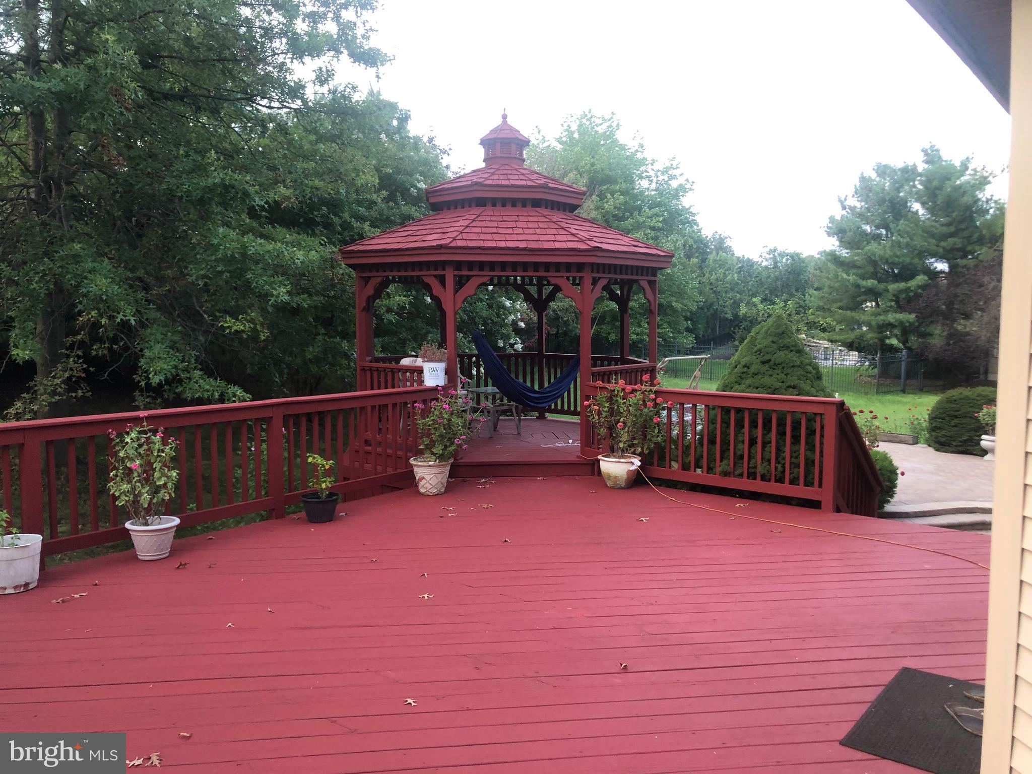 18 Jewel Road Princeton Junction, NJ 08550 - Photo 56 of 66 a view of a deck with wooden floor and roof with a garden