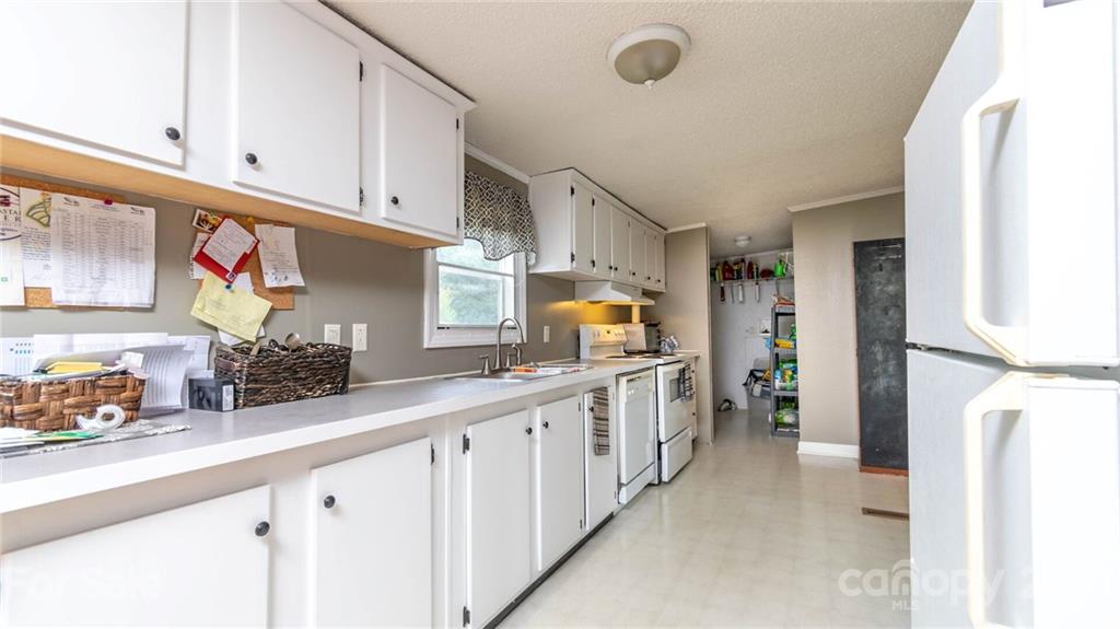 449 Divide Loop Flat Rock, NC 28731 - Photo 11 of 36 a kitchen with white cabinets and refrigerator