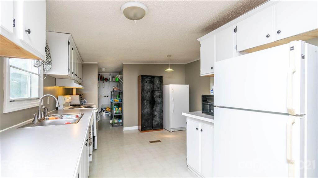 449 Divide Loop Flat Rock, NC 28731 - Photo 12 of 36 a kitchen with refrigerator and car