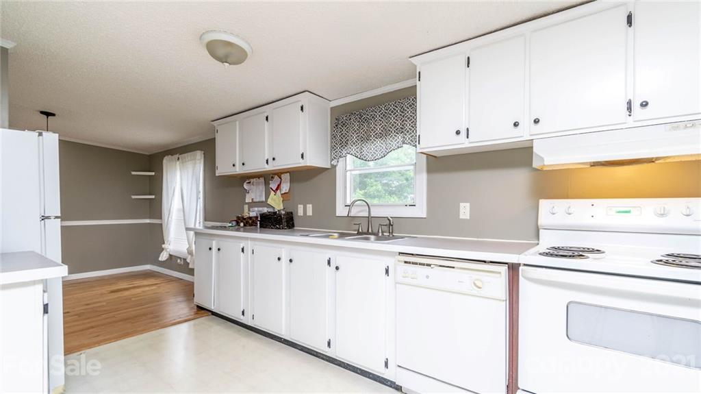 449 Divide Loop Flat Rock, NC 28731 - Photo 13 of 36 a kitchen with granite countertop white cabinets and white appliances