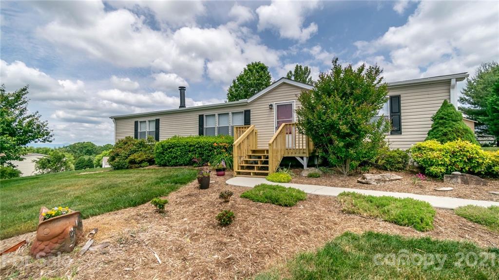 449 Divide Loop Flat Rock, NC 28731 - Photo 3 of 36 a front view of a house with a garden and trees