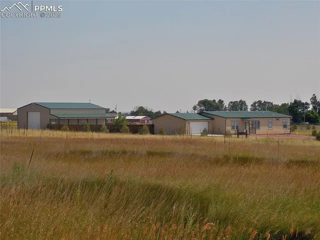 a view of a yard with wooden fence