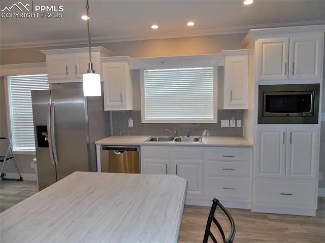 a kitchen with stainless steel appliances kitchen island granite countertop a stove a sink a refrigerator and cabinets
