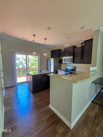 a kitchen with kitchen island granite countertop wooden floors and wide window