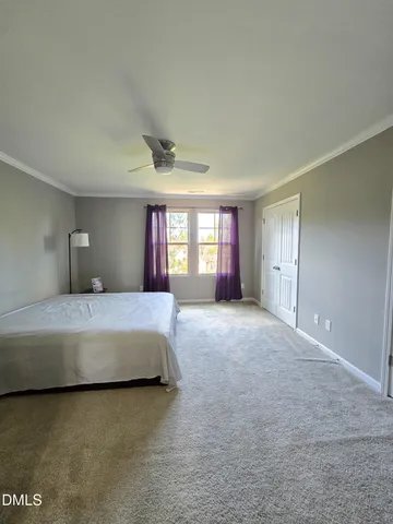 a spacious bedroom with a bed and a chandelier