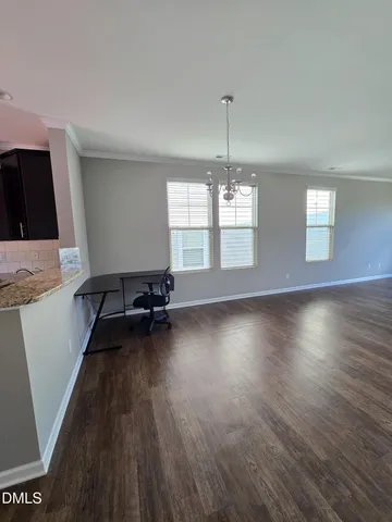 a view of a livingroom with furniture wooden floor and chandelier