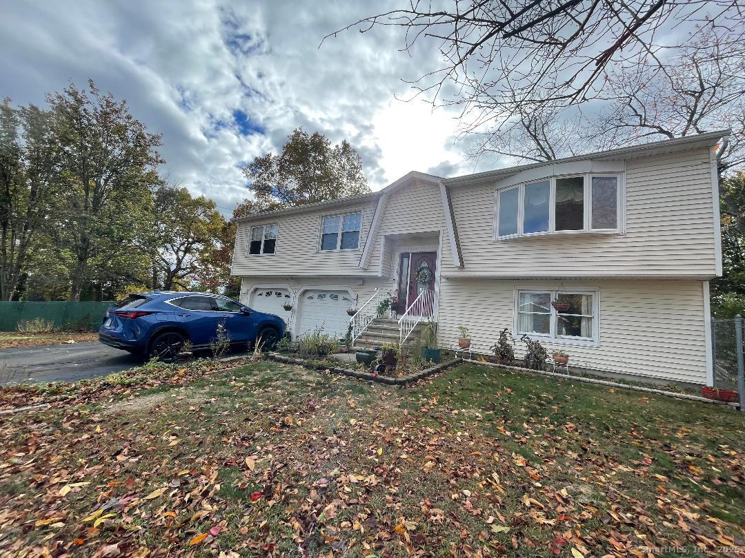 a view of a house with a yard and a car parked in it