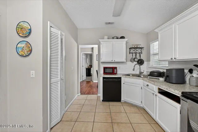 a kitchen with a sink a stove top oven and a refrigerator