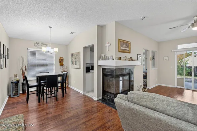a living room with furniture a fireplace and dining table