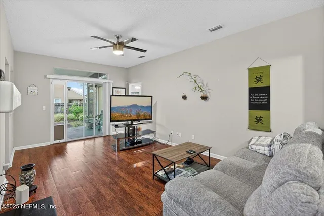 a living room with furniture and a flat screen tv with wooden floor