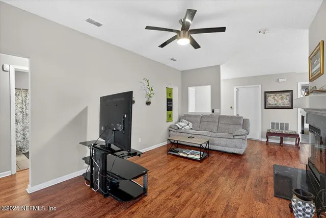a living room with furniture and a wooden floor