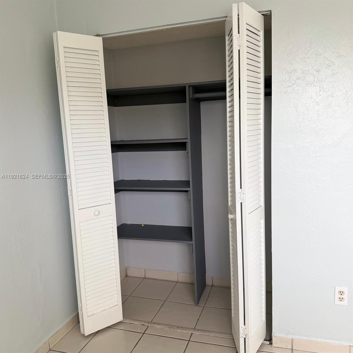 5501 Northwest 7th Street, Unit E301 Miami, FL 33126 - Photo 13 of 28 a view of walk in closet with empty racks