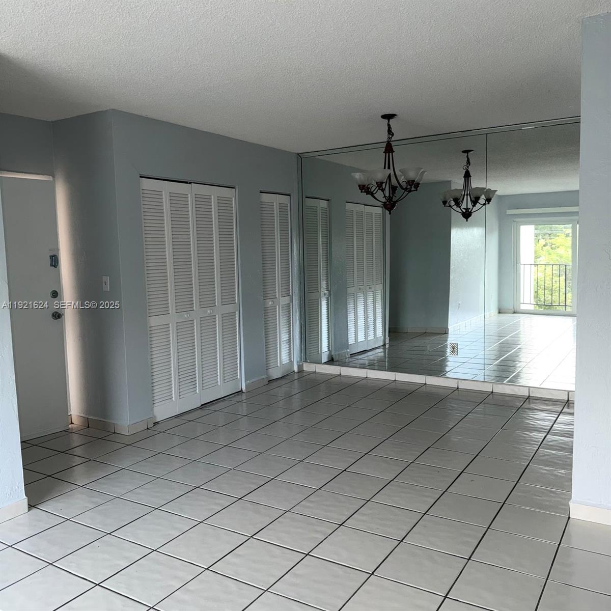 5501 Northwest 7th Street, Unit E301 Miami, FL 33126 - Photo 5 of 28 an empty room with entrance and windows