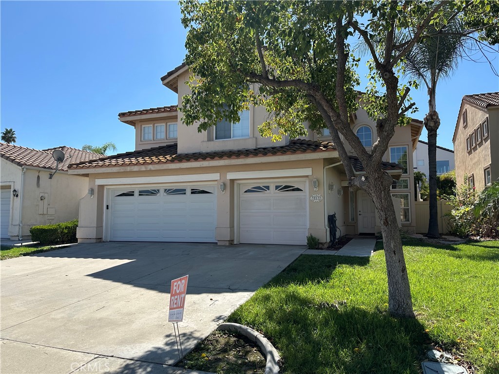 a view of a white house next to a yard with plants and large trees