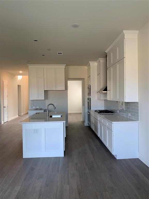 216 Lk Frst Trail Anna, TX 75409 - Photo 4 of 9 a large kitchen with cabinets wooden floor and stainless steel appliances