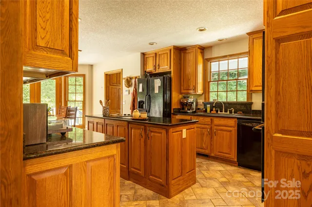 a kitchen with stainless steel appliances granite countertop a stove a sink and a refrigerator