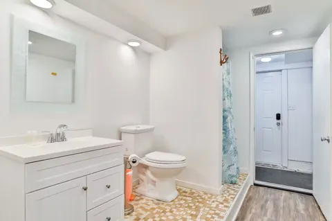 a bathroom with a sink a toilet a shower and a mirror