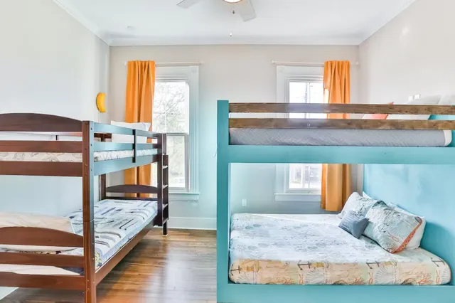 a bedroom with a bed and large windows