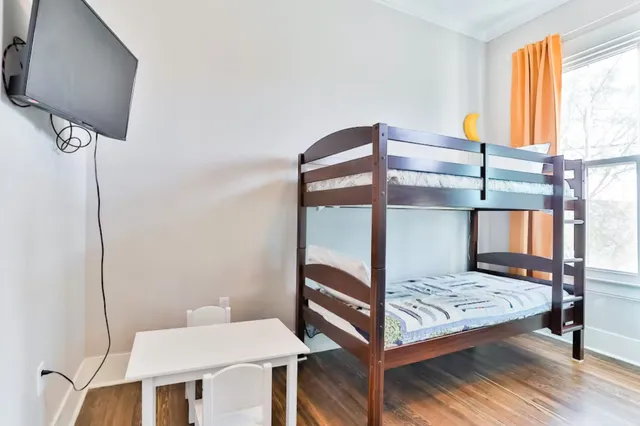 a bedroom with a large bed and a flat tv screen on dresser