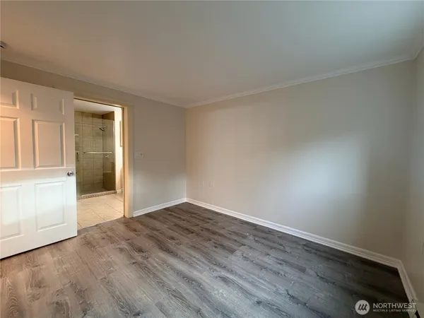 a view of an empty room with wooden floor