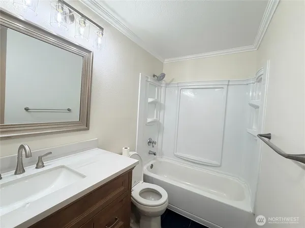 a bathroom with a granite countertop sink toilet a mirror and shower