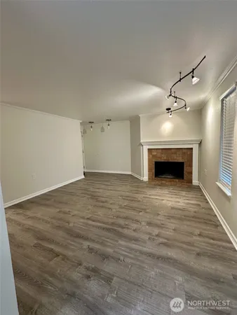 a view of empty room with wooden floor and fireplace