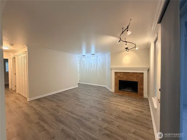 a view of empty room with fireplace and wooden floor