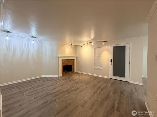 a view of empty room with wooden floor and fireplace