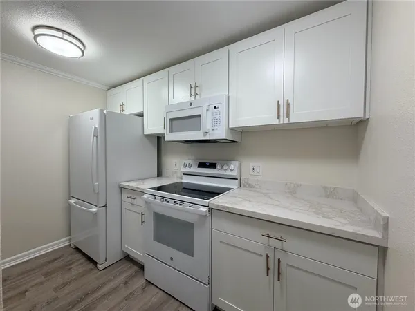 a kitchen with cabinets stainless steel appliances and a wooden floor