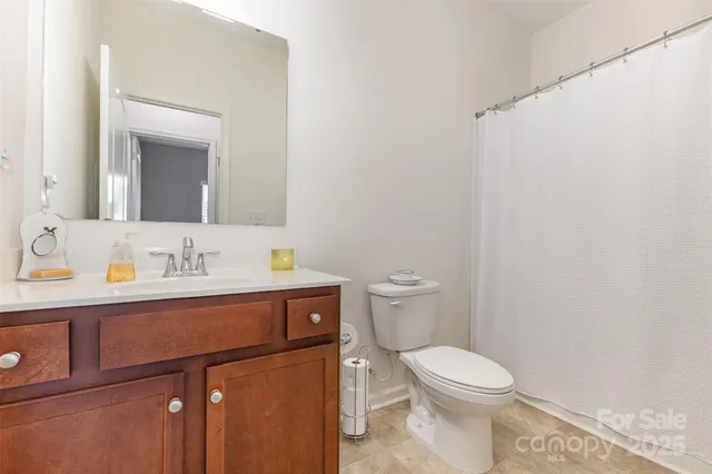 a bathroom with a toilet a sink a mirror and vanity