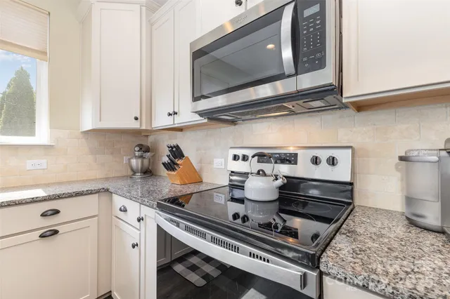 a kitchen with a stove a microwave and cabinets