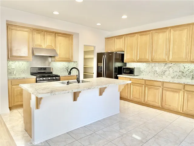 a kitchen with stainless steel appliances granite countertop a stove a sink dishwasher and a refrigerator