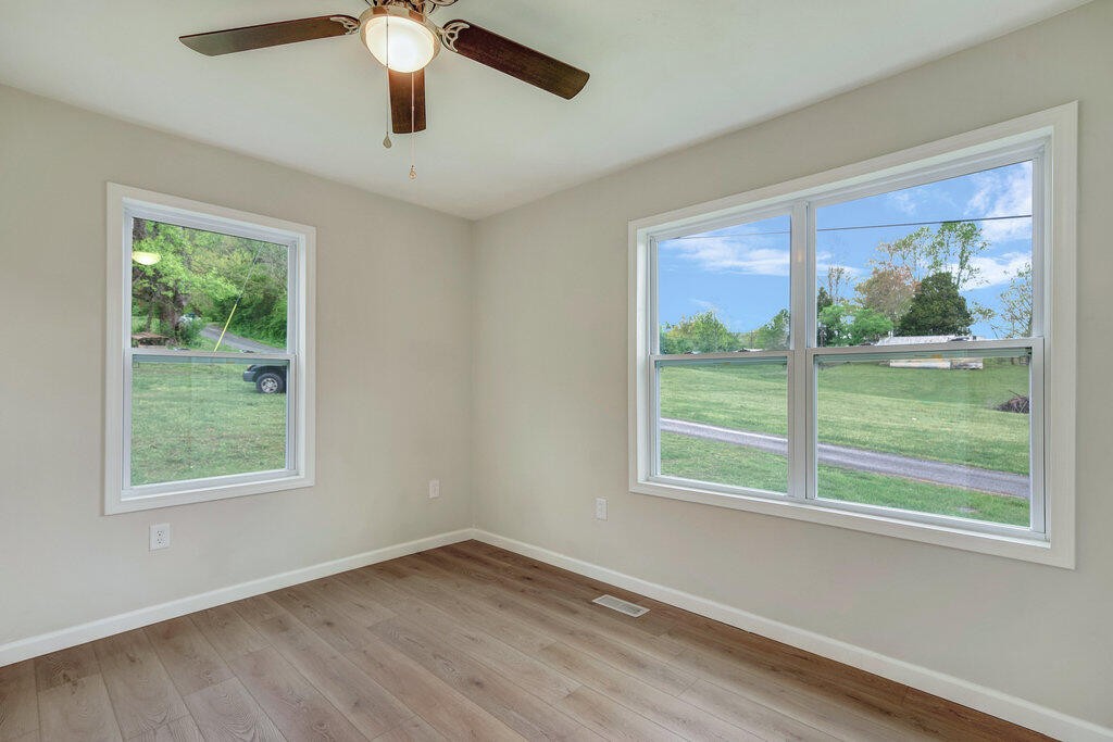 183 Earl Ezell Road Spring City, TN 37381 - Photo 12 of 30 a view of an empty room with wooden floor and a window